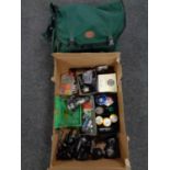 A Shakespeare fishing bag containing waterproofs together with a box containing fishing reels, line,