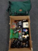A Shakespeare fishing bag containing waterproofs together with a box containing fishing reels, line,