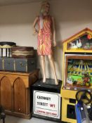 A shop mannequin in 60's dress on a Carnaby Street London wooden plinth.