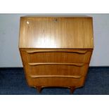 A 20th century teak fall fronted bureau fitted with three drawers