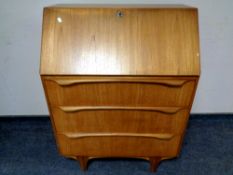 A 20th century teak fall fronted bureau fitted with three drawers