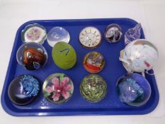 A tray containing assorted glass paperweights including Caithness together with an art glass bauble.