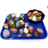 A tray containing a quantity of polished stone, treen and glass egg ornaments including Mdina glass.