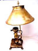 A brass retro style table lamp in the form of an oil lamp on paw feet.