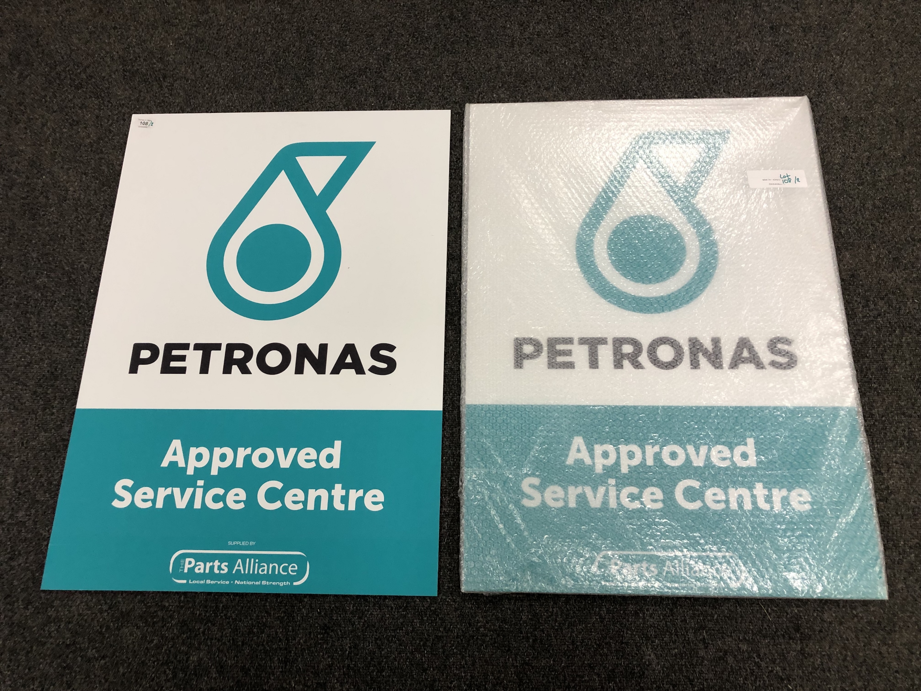 Three advertising signs : Petronas - Approved Service Centre, both the same, each 84 cm x 60 cm.