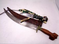 A Philippines knife with curved blade and wooden handle in a stitched leather sheath together with