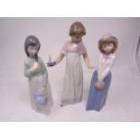 A Nao figure- Girl with candle, together with two further Nao figures.