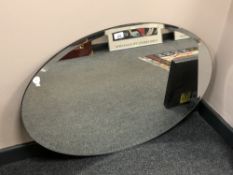 A frameless oval mirror, 89 x 60 cm.