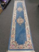 A Chinese embossed carpet runner on blue ground.