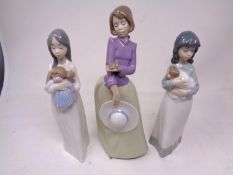 A Nao figure - Girl with bird in hand, together with two further Nao figures.