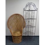 A folding metal five tier corner whatnot stand together with a wicker peacock chair.