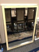 A contemporary bevelled mirror in a cream frame,