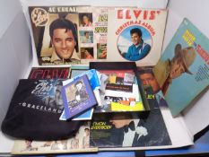 A tray containing Elvis Presley vinyl LPs and memorabilia.
