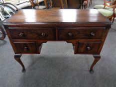 A walnut Queen Anne style four drawer knee hole dressing table.