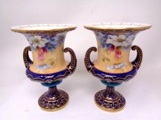 A pair of Royal Worcester hand-painted gilded vases decorated with flowers.