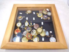 A pine display frame containing a quantity of contemporary pocket watches.