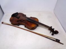 A late 19th century German violin and bow with carved lions head scroll, two-piece 14" back,