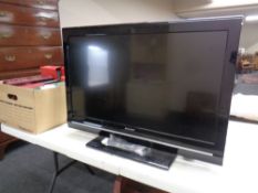 A Sharp 32" LCD TV with lead and remote.