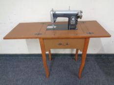 A Universal sewing machine in teak effect table.