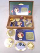 A cigar box containing a quantity of gold plated commemorative coins and key rings.