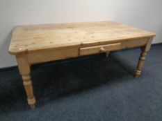 A pine farmhouse kitchen table with a fitted drawer together with a set of six pine chairs.