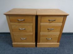 A pair of contemporary oak three drawer bedside chests.