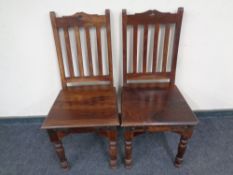 A pair of eastern hardwood dining chairs.