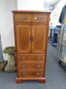A reproduction inlaid mahogany double door cabinet fitted with drawers.