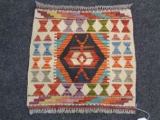 A Chobi kilim fringed woolen mat (51cm x 53cm).