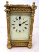 A decorative brass-cased French carriage clock with key.