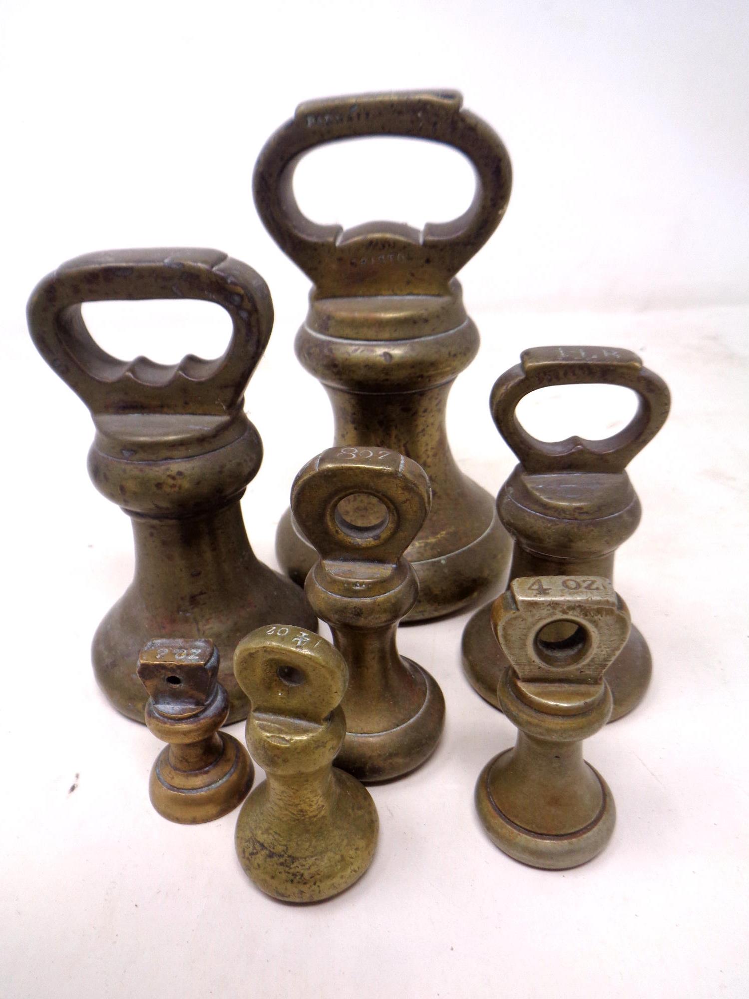 A set of seven brass graduated weights.