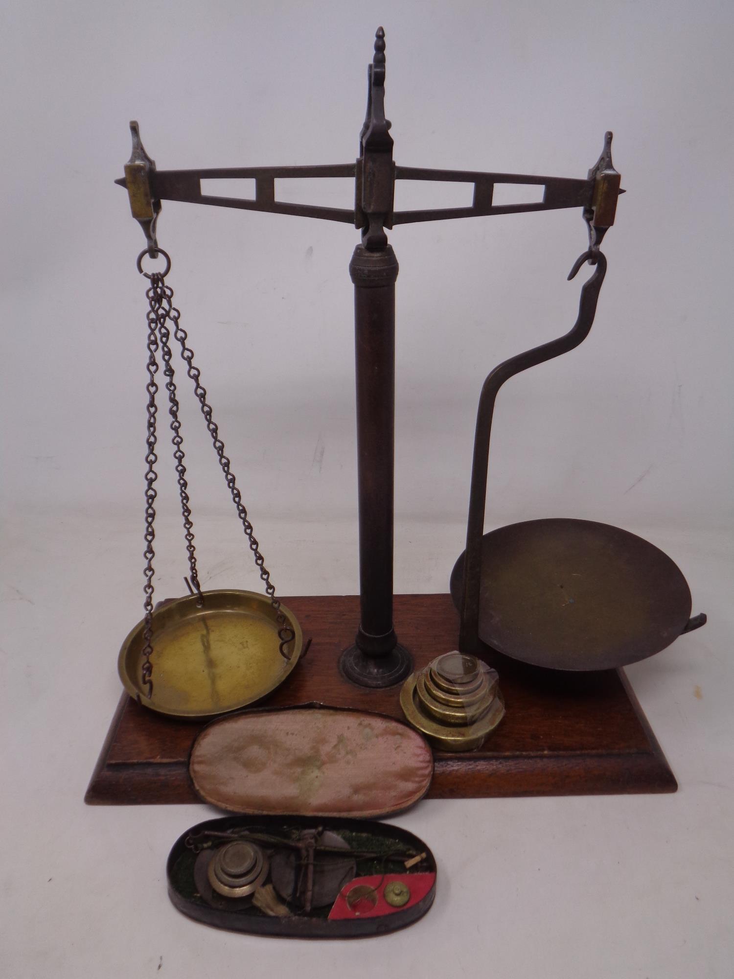 A set of 19th century chemist's pan scales mounted on a board with weights together with a pair of