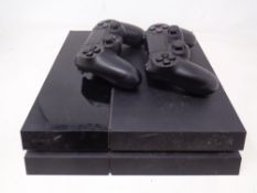 A Sony Playstation 4 with two wireless controllers (no leads, as found).