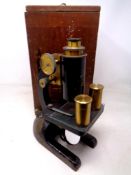 A vintage black lacquered and brass microscope by R&B Ltd of Leeds, in case.