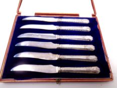 A set of six silver handled butter knives in case.