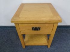 A contemporary oak two tier lamp table with a fitted drawer.