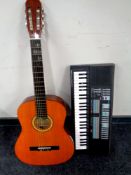 A Lauren model 100 acoustic guitar together with a Yamaha PSS570 keyboard.