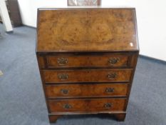 A 20th century burr walnut writing bureau fitted with four drawers.