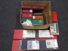 A box containing 11 albums of first day covers.