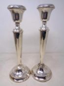 A pair of silver candlesticks on weighted bases (height 29.5cm).