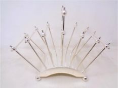 A silver plated six-slice toast rack, designed by Christopher Dresser.