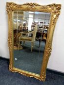 A decorative gilt framed bevelled mirror 65 cm x 109 cm