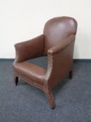 An early 20th century brown studded armchair.