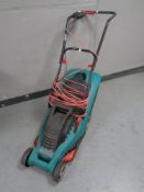 A Bosch Rotak 34 electric lawn mower with grass box and lead.