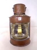 A copper cased miniature ships lamp.