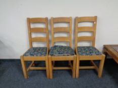 Three heavy light oak dining chairs.