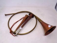 An antique copper and brass coiled hunting horn together with two further short stemmed hunting
