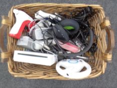 A wicker basket containing a Nintendo Wii with leads and stand together with further computer