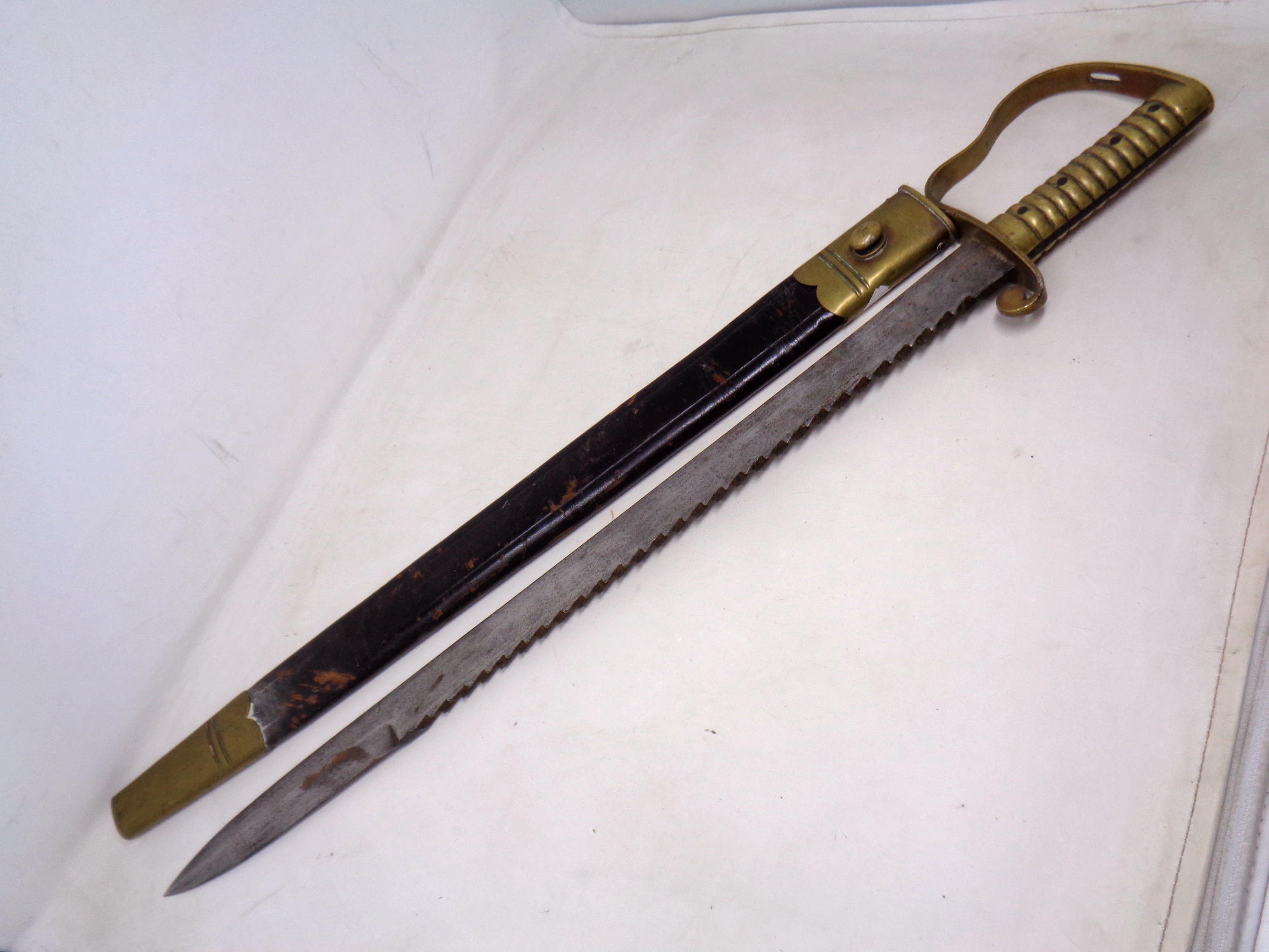 A British 1856 pattern Pioneer's sword bayonet by Wilkinson of London in brass and leather sheath.