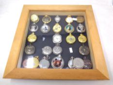 A pine display frame containing a quantity of contemporary pocket watches.